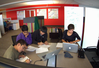 Students discussing their school research project and working with ProQuest products.